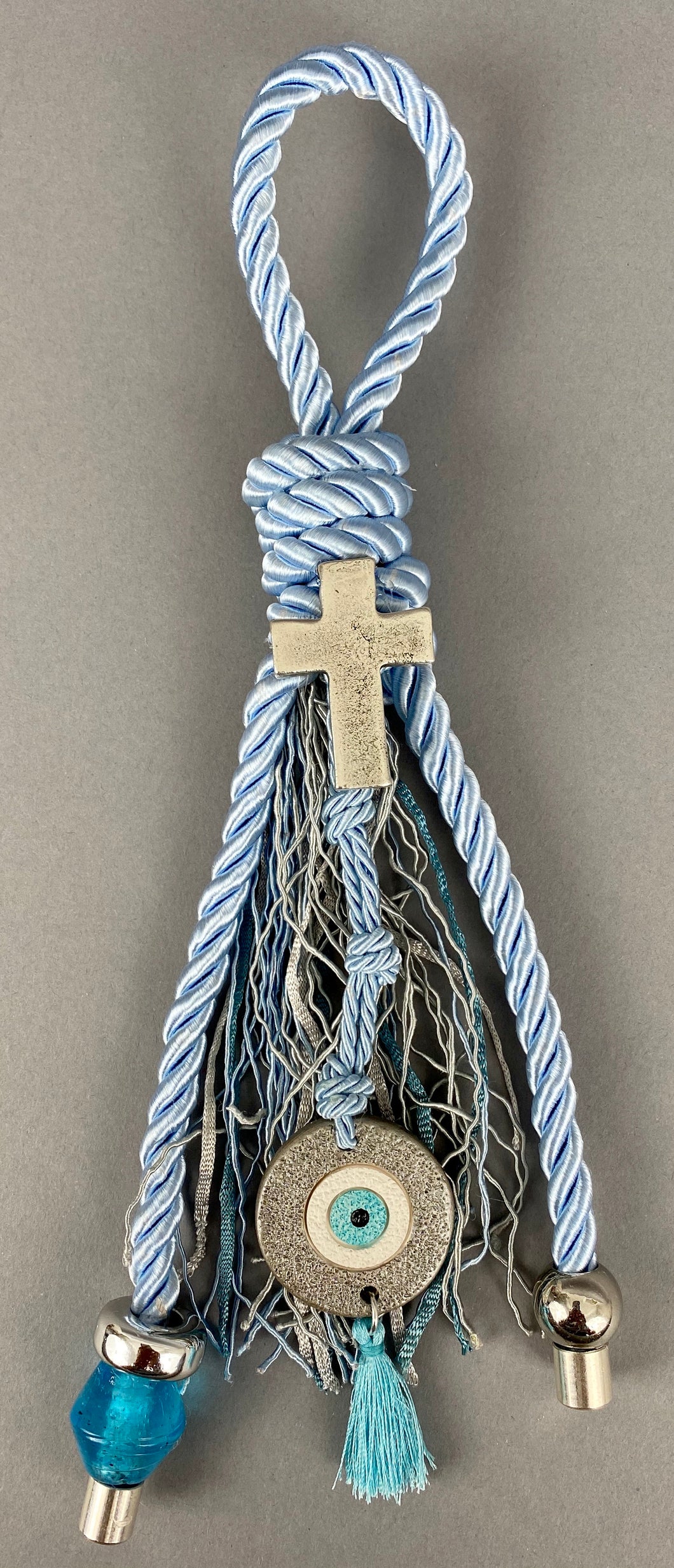 Gouri 1010 Pearl Baby Blue Cord Gouri, large Metal  Cross, Ceramic Mati,  large Murano Glass Bead.  Measures 9” in length.